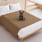 Ragnar seated on the khaki quilted Pet Furniture Cover Blanket on a bed.