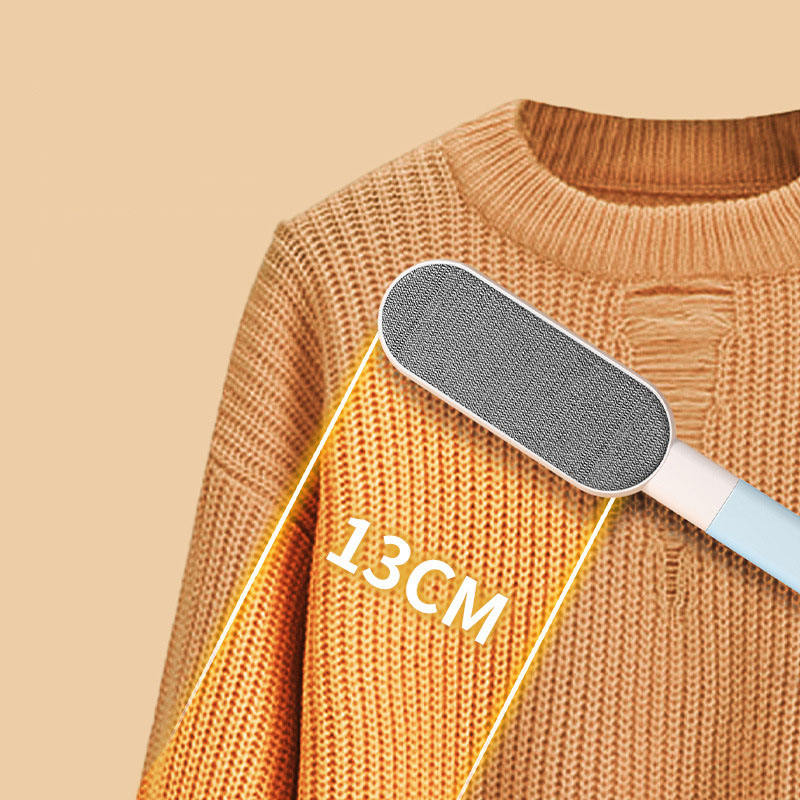 Blue-and-white double-sided pet hair brush on an orange knit sweater with a 13 cm measurement graphic.