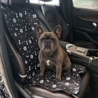 Ragnar seated on the black paw-and-bone patterned Single-Seat Pet Cover.